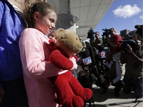 Courtney Gelinas talks with the news media after being reunited with her bear Rufus, at the Fort Lauderdale-Hollywood International Airport on Jan. 10, 2017, in Fort Lauderdale, Fla. Gelinas, of Windsor, Ont., was travelling home with her family after a Caribbean cruise. They became separated from their belongings as they fled during last week's shooting at the airport in which five people were killed.