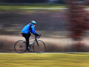 A cyclist cruises along a trail near the Little River on Monday, Jan., 23, 2017, in Windsor, Ont. on a mild day.