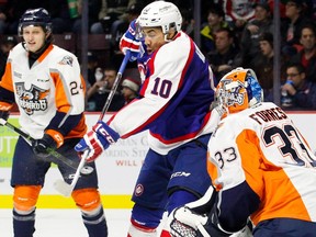 Forward Jeremiah Addison (10) of the Windsor Spitfires deflects the puck against goaltender Garrett Forrest of the Flint Firebirds on Dec. 31, 2016 at the WFCU Centre in Windsor, Ont.