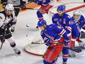 A loose puck is batted out of the air near the Kitchener Rangers goal by Rangers forward Greg Meireles (88) as teammates Dylan Di Perna (8) and goalie Luke Opilka (29) look on. Windsor Spitfires forward Gabe Vilardi (13) moves in during an OHL game in Kitchener, Ont., on Jan. 17, 2017.