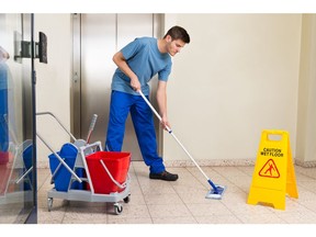 A janitor mops a hallway.