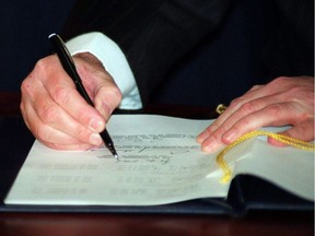 Canadian Prime Minister Brian Mulroney signs the North American Free Trade Agreement during a signing ceremony in Ottawa, on Dec.17, 1992.