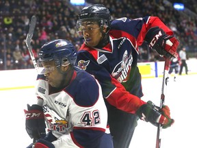 Saginaw Spirit defender C.J. Garcia gets tied up with Windsor Spitfires Cole Purboo during third period Ontario Hockey League action at the WFCU Centre in Windsor on Jan. 17, 2017.