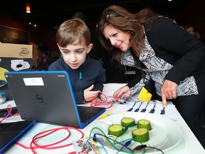 Neil Polachok, 8, a Grade 3 student at St. Rose School displays a circuit experiment with teacher Barbara Gaspard from Holy Names School in Essex during a robotics workshop at Brewing Bros. Beverage Co., on Walker Road on Jan. 26, 2017.