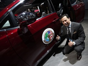 Minister of Economic Development, Employment and Infrastructure Brad Duguid is photographed next to the Chrysler Pacifica during the media preview of the North American International Auto Show in Detroit on Jan. 10, 2017.