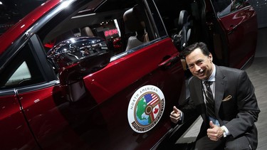 Minister of Economic Development, Employment and Infrastructure Brad Duguid is photographed next to the Chrysler Pacifica during the media preview of the North American International Auto Show in Detroit on Jan. 10, 2017.