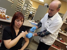Gary Willard gives Julie Wright her flu shot at the Ziter Pharmacy in Windsor on Jan. 5, 2017.