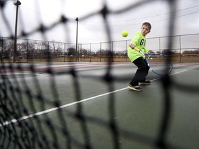 Damian Gorski, 9, plays tennis with his father Mark at the public tennis courts at Central Park in Windsor, Ont., on Jan. 24, 2017. The City of Windsor approved $100,000 to repair and fix the cracked and aged courts.