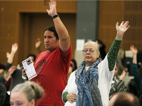 Richard Dalkeith, left, and Lorena Shepley ask for a show of hands to support an emergency resolution to raise Ontario Works rates during discussions on the Basic Income pilot project Monday at University of Windsor's Vanier Hall.