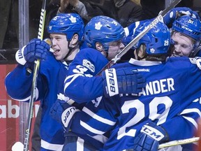 Toronto Maple Leafs defenseman Jake Gardiner, right, is mobbed by teammates after scoring his game winning goal during overtime NHL hockey action against the Winnipeg Jets, in Toronto on Tuesday, February 21, 2017. THE CANADIAN PRESS/Chris Young