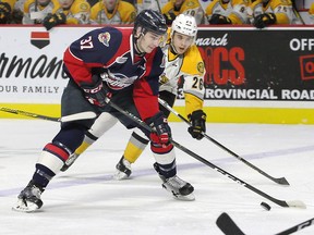 Windsor Spitfires Graham Knott carries the puck against Sarnia Sting Franco Sproviero, right, in OHL action from WFCU Centre February 16, 2017.