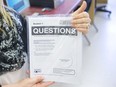 A London, Ont., vice-principal holds a paper copy of the EQAO standardized test in a computer lab on March 24, 2015.