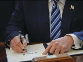 President Donald Trump signs an executive order in the Oval Office of the White House in Washington on Feb. 9, 2017.