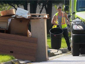 A Green for Life employee picks up garbage on Lori Street in Windsor on Oct. 6, 2016. The city and the Town of Tecumseh held special garbage pickups for residents hit by the flood.
