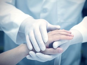 In this undated file photo, a doctor holds a patient's hands.