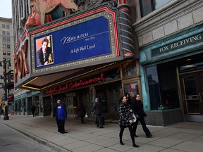 Visitors pass the Fox Theatre during a public visitation for Detroit Red Wind and Tigers owner Mike Ilitch in Detroit on Wednesday, February 15, 2017.
