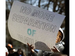 Jaciel Hernandez, 7, from Harnett Co., holds a sign as hundreds come out to protest the federal government's immigration policies during a rally held at Moore Square in Raleigh, N.C., on Feb. 16, 2017. Immigrants around the U.S. stayed home from work and school Thursday to demonstrate how important they are to America's economy and way of life, and many businesses closed in solidarity, in a nationwide protest called A Day Without Immigrants. (Chris Seward/The News & Observer via AP) ORG XMIT: NCRAL101