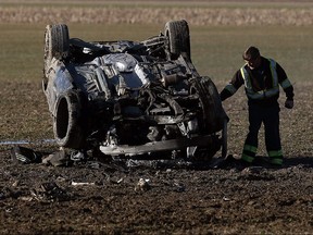 A tow truck driver prepares to remove a wrecked car in a field along the 4th Concession Road in Amherstburg on Monday, February 13, 2017.