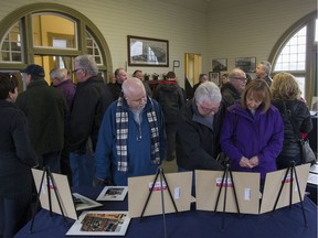 People browse through photographs at the Blast From Our Pasts photo exhibit before a plaque unveiling honouring the Essex Railway Station, Sunday, Feb. 12, 2017.