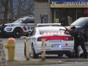 Windsor police officers take up positions  near an apartment building where they responded to a threats call on the corner of Sandwich Street and South Street, Monday, Feb. 20, 2017.