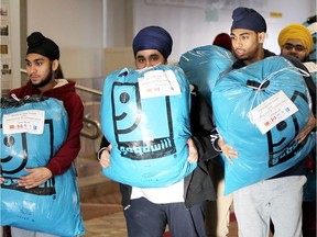 Tecumseh, Ontario. February 17, 2017. Members of the Sikh Youth Council, priests and Sikh community leaders gather at Windsor Gurdwara on County Road 42 to donated 25 bags of winter clothing to Goodwill Windsor Essex County February 17, 2017. In all, 500 winter coats, sweaters, socks and scarves were collected. "This successful drive ran for six weeks celebrating the martyrdom of four sons of Guru Gobind Singh, the tenth Sikh master, for the well-being of humanity," said Triman Singh.  (NICK BRANCACCIO/Windsor Star)