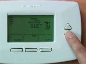This image provided by the US Environmental Protection Agency shows a person programming a thermostat for a furnace/HVAX system. Consider investing in a programmable thermostat to maximize energy efficiency. "We recommend keeping it set to between 68 and 72 degrees when people are home, and then down to between 55 and 65 when no one is home and at night," says Lauren Urbanek, senior energy policy advocate for the Natural Resources Defense Council. (US Environmental Protection Agency via AP)