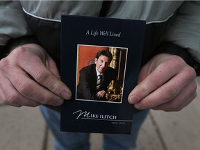 Ron Slowinski holds a booklet during a public visitation for Detroit Red Wings and Tigers owner Mike Ilitch at the Fox Theatre in Detroit on Feb. 15, 2017.