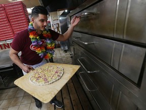 Pizza maker Sleiman Chams prepares an Hawaiian pizza at Capri Pizza in Windsor on Feb. 23, 2017. The Icelandic President Gudni Johannesson set off an international debate after casually joking last week that pizza topped with pineapple should be outlawed.