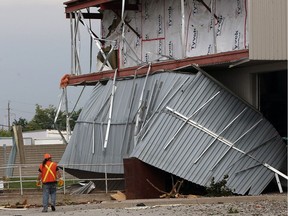 An EnWin worker observes damaged to Graybar Canada on Deziel Drive on Thursday Aug. 25, 2016, the day after a tornado caused millions of dollars in damage.