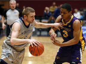 Windsor Lancers Mitch Farrell, left, drives against Laurier Golden Hawks Shamar Burrows in OUA men's basketball action on Feb. 8, 2017.