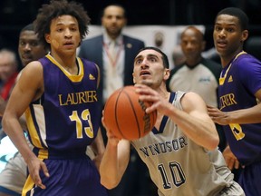 University of Windsor Lancers Mike Rocca drives between Laurier Golden Hawks Tevaun Kokko, left, and Joseph Fo in OUA men's basketball action at the Colosseum at Caesars Windsor on Feb. 8, 2017.