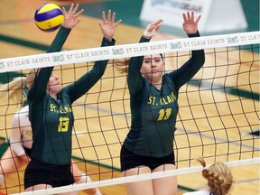 St. Clair Saints Jessica Masse, left, and Kaila Crough go up for a block against Niagara College Knights' Amy Bultje, bottom right, during the OCAA Women's Volleyball Championships bronze medal game last year at the St. Clair SportsPlex.