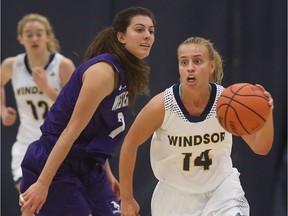 Windsor guard Kaylee Anagnostopoulos, right, drives past and Western  forward Julie Curran during first half OUA  action at the St. Denis Centre in Windsor on Jan. 11, 2017.