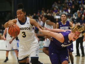 Windsor's Kayah Clarke (3) and Western's  Mackenzie Puklicz battle for the basketball during OUA action at the St. Denis Centre in Windsor, Ont., on Jan. 11, 2017.