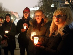 Hiba Hamed, left, Jerome St. Denis, Allison Chandler and Starr Meloche take part in a candlelight vigil at City Hall Square for those who died at a Quebec City mosque. A large crowd of about 300 braved the bone-chilling wind Jan. 31, 2017.