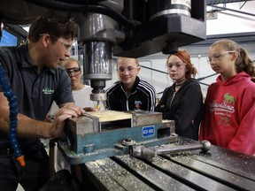 St. Clair College skilled trades instructor Rob Kobielski, left, demonstrates on a three-axis CNC mill for students Faye Hoster, Samantha Clements, Arial McCallum and Emily St. Croix, right, during Build a Dream on July 14, 2016.