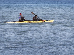 Kayakers in a tandem unit row along the Detroit River on Feb. 20, 2017 near the Ambassador Bridge.