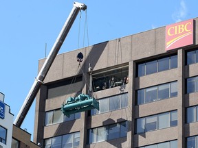 A 200-tonne crane hoists a chiller weighing 16,500 pounds to the 14th floor of the CIBC Building at 100 Ouellette Ave., on March 15, 2017. Owners of the building, Mikhail Holdings, will spend almost $1 million for the project, which included about a dozen specialists with Johnson Controls and sub-trades. Windows and a portion of concrete wall on the 14th floor were removed for the tricky installation.
