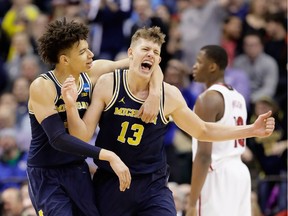 Moritz Wagner #13 of the Michigan Wolverines celebrates a shot with D.J. Wilson #5 in the second half against the Louisville Cardinals during the second round of the 2017 NCAA Men's Basketball Tournament at the Bankers Life Fieldhouse on March 19, 2017 in Indianapolis, Indiana. Michigan Wolverines won 73-69.