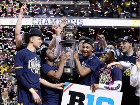 The Michigan Wolverines celebrate with the trophy after defeating the Wisconsin Badgers to win the Big Ten Basketball Tournament Championship game at Verizon Center on March 12, 2017 in Washington, DC.
