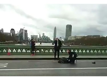 An video grab obtained from the Twitter account of Polish politician and journalist Radosaw Sikorski, shows a man on the ground receiving assistance on Westminster Bridge on March 22, 2017 in London.