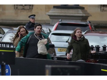 People leave after being evacuated from the Houses of Parliament in central London on March 22, 2017 during an emergency incident.