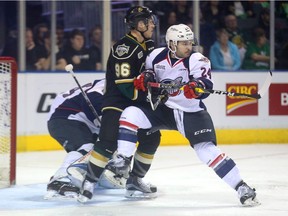 Daniel Robertson of the Spitfires puts everything into fighting off Dante Salituroof the Knights in front Michael DiPietro of the Spitfires during their opening playoff game at Budweiser Gardens on Friday March 24, 2017.