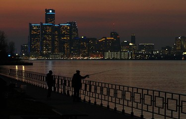 The sun sets behind the Detroit skyline as a pair of fishermen try for one last catch on a warm fall day on Nov. 15, 2016.