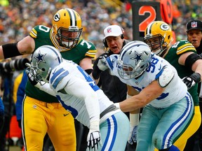 T.J. Lang (70) of the Green Bay Packers confronts Windsor native Tyrone Crawford (98) and Nick Hayden (96) of the Dallas Cowboys during the 2015 NFC Divisional Playoff game at Lambeau Field on Jan. 11, 2015 in Green Bay, Wis.