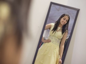 Sally Elsayed, 18, a Grade 12 student at St. Joseph High School, tries on a prom dress at Say Yes to the Prom Dress at New Beginnings Saturday, March 18, 2017.