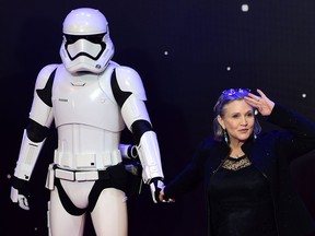 This photo taken on Dec. 16, 2015, shows actress Carrie Fisher posing with a storm trooper as she attends the opening of the European premiere of Star Wars: The Force Awakens in central London.