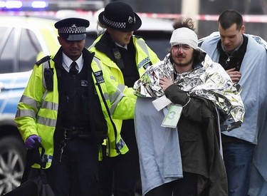 A member of the public is treated by emergency services near Westminster Bridge and the Houses of Parliament on March 22, 2017 in London, England.