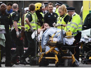 A woman is treated by emergency services near Westminster Bridge and the Houses of Parliament on March 22, 2017 in London, England.