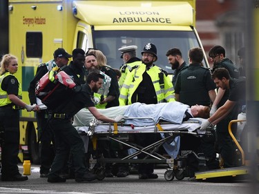 A member of the public is treated by emergency services near Westminster Bridge and the Houses of Parliament on March 22, 2017 in London, England. A police officer has been stabbed near to the British Parliament and the alleged assailant shot by armed police. Scotland Yard report they have been called to an incident on Westminster Bridge where several people have been injured by a car.